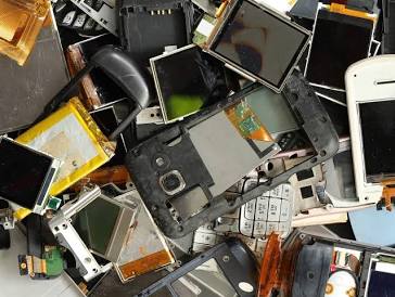 worker sorting parts to recycle your old smartphone at an e-waste facility